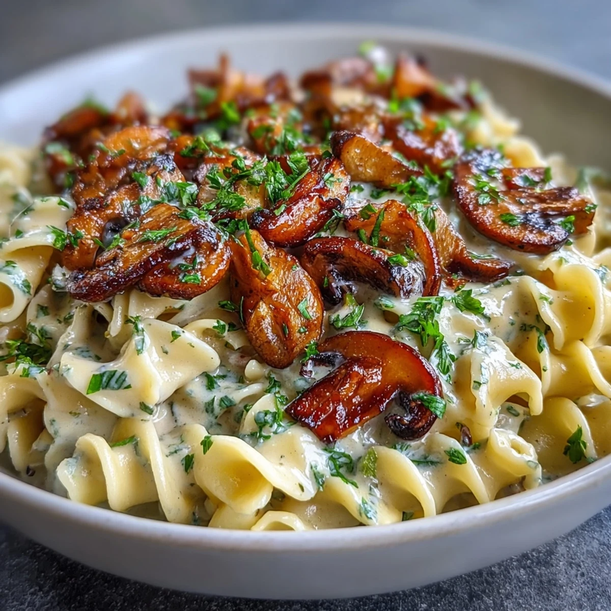 Creamy Mushroom Stroganoff features golden sautéed mushrooms and silky sauce tossed with fettuccine noodles in a skillet.