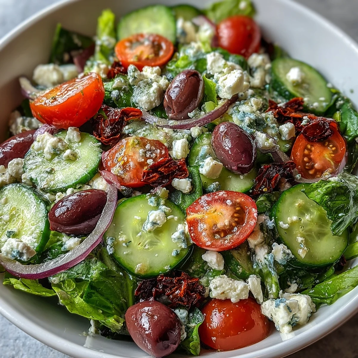 Fresh Mediterranean Green Salad Bowl with crisp spring greens, juicy tomatoes, crunchy cucumber, briny Kalamata olives, creamy feta, and tangy Greek dressing.  