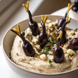 Smooth white bean Winter Dip topped with cute and clever olive penguin decorations for your guests.