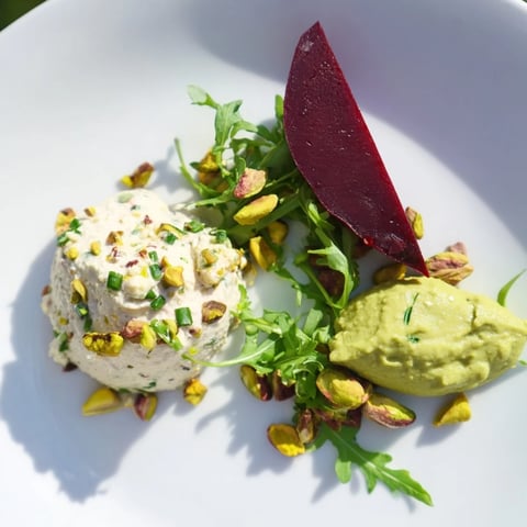 Elegant Lucky Clover Seasonal Starters plated with vibrant green pea puree, beets, and goat cheese mousse.