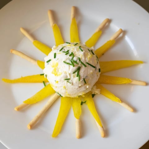 Bright yellow bell peppers and creamy goat cheese sunburst appetizer, ready to enjoy with breadsticks.