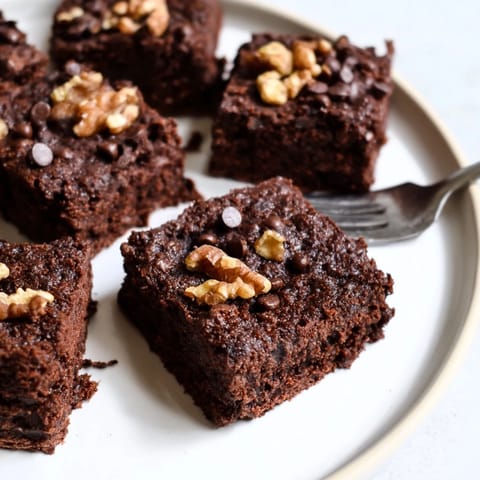 Decadent nut-milk pulp brownies, topped with chocolate chips, perfect for dessert lovers.  