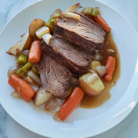 Fork-tender Pickle Brine Pot Roast, glistening from its savory juices, ready to be served.