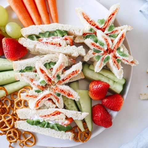 Beach Day Starfish Snack Spread: A colorful platter of starfish sandwiches, grapes, and carrots; ideal for kids' parties.