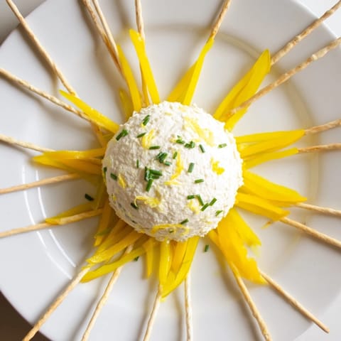 Tuscan sunburst appetizer: tangy goat cheese in the center, surrounded by colorful pepper strips and breadsticks.