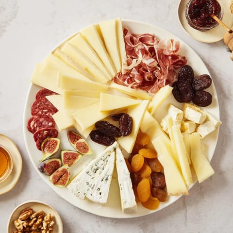 Delectable Plateau des Rois Mages Gourmand features assorted cheeses and charcuterie alongside dried fruits and nuts.