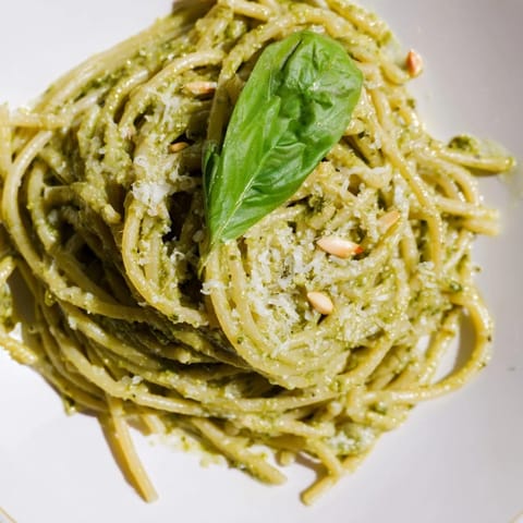 A close-up of Creamy Sunflower Seed Pesto Pasta with golden toasted seeds, silky cream sauce, and fresh basil garnish.