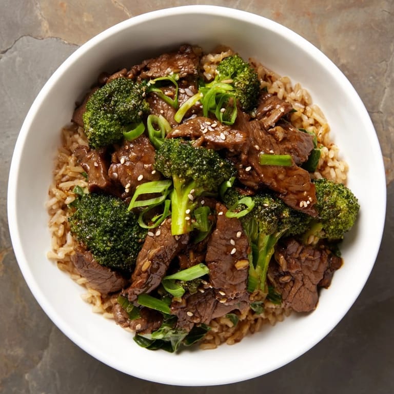 Steaming bowl of flavorful slow-cooker Beef & Broccoli, a complete meal with fresh greens and brown rice.