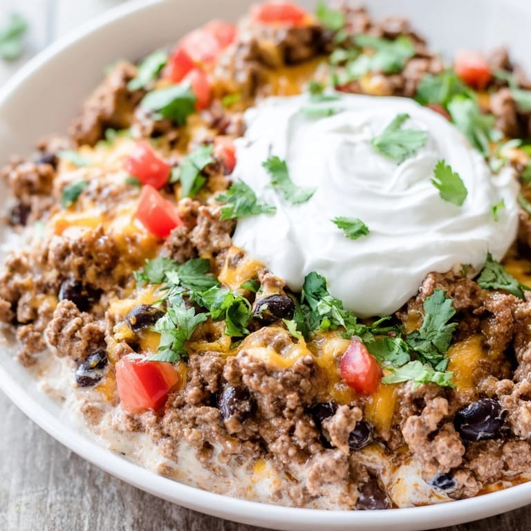 The warm, inviting Slow Cooker Cream Cheese Taco Dip, with toppings, perfect for a crowd-pleasing appetizer.
